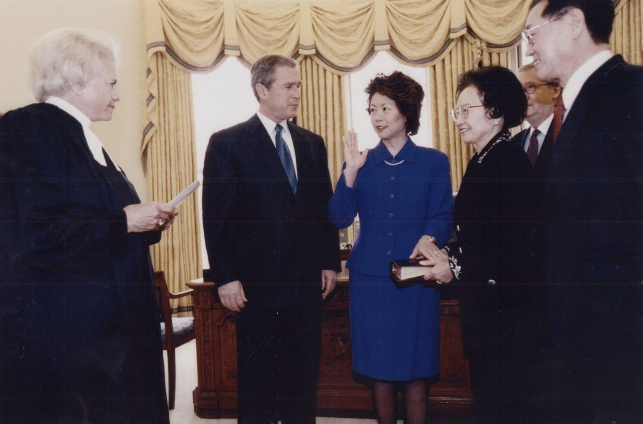 In the Oval Office. Justice Sandra Day O'Connor swearing in Elaine Chao as Secretary of Labor with President George W. Bush; parents, Dr. James S. C. Chao, Mrs. Ruth Mulan Chu Chao; and husband Mitch McConnell looking on.